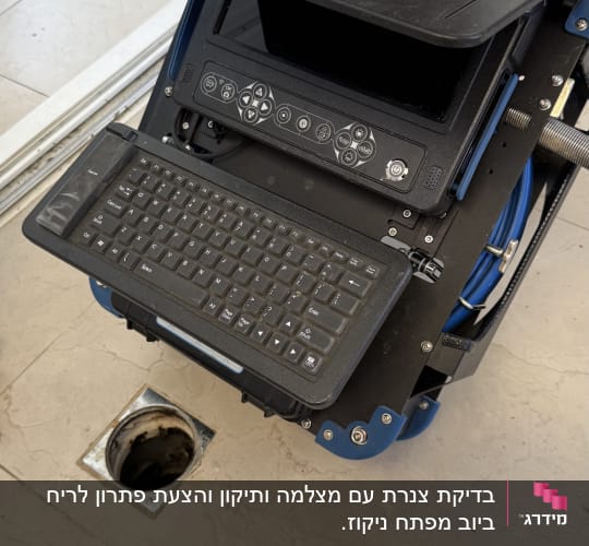 מצלמת אינסטלציה עם מקלדת ליד פתח ביוב